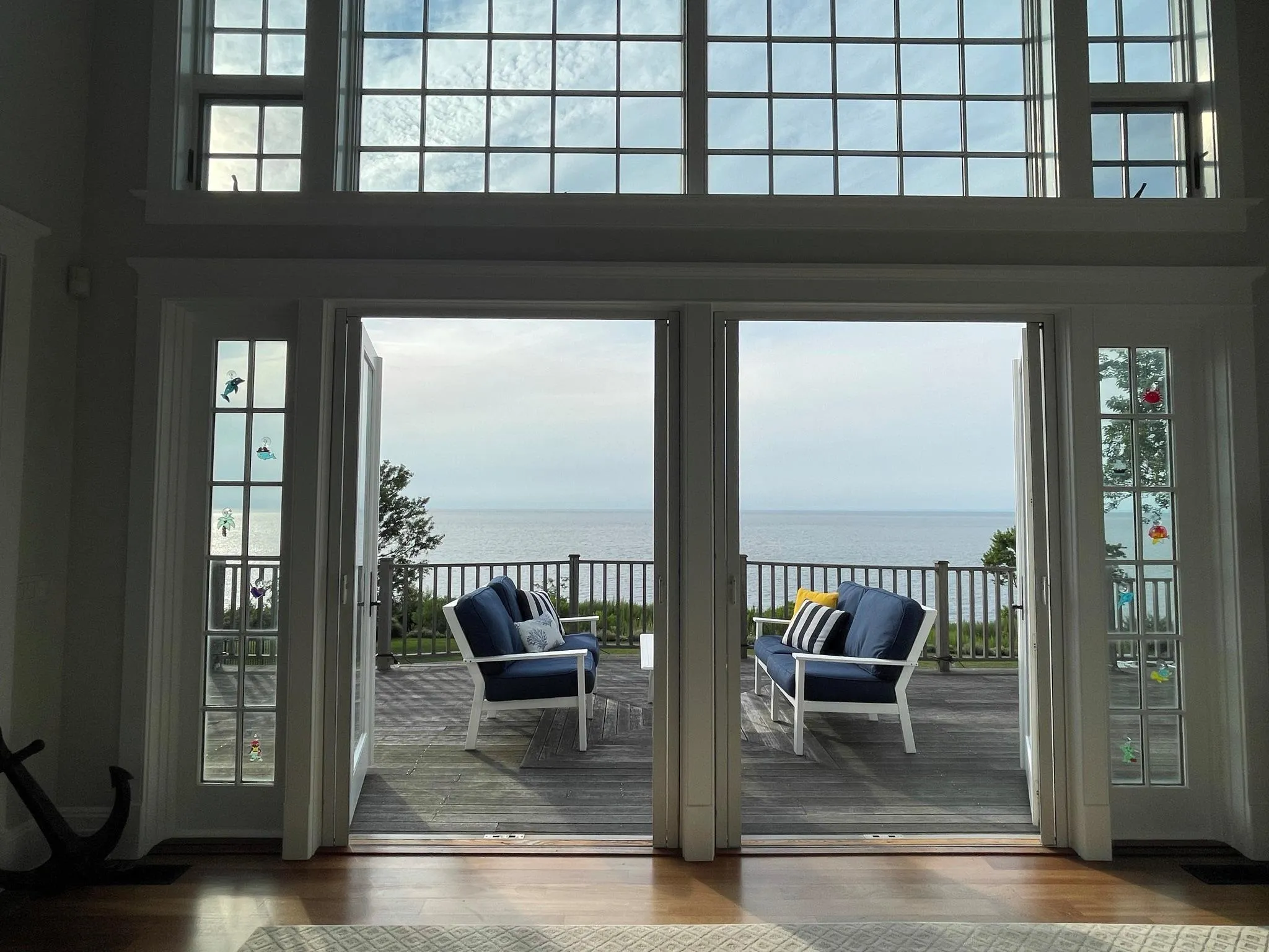 Doorway featuring a water view, wood-type flooring, and a high ceiling Doorway featuring a water view, wood-type flooring, and a high ceiling