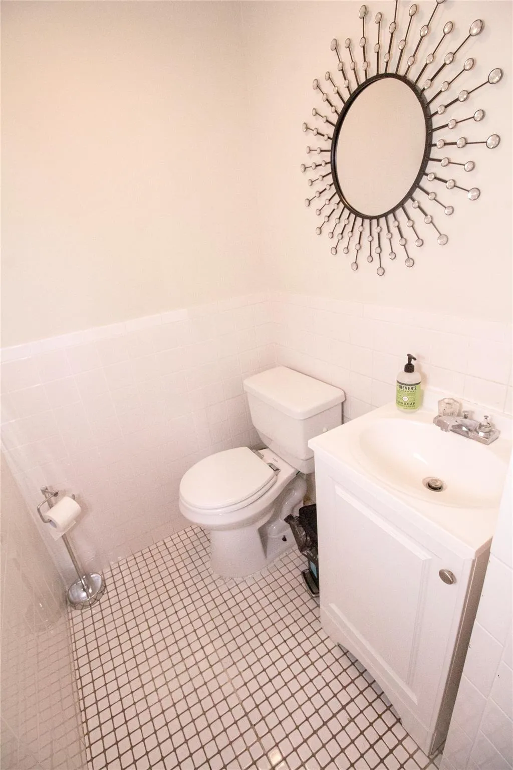 Bathroom with tile patterned floors, vanity, tile walls, and toilet Bathroom with tile patterned floors, vanity, tile walls, and toilet