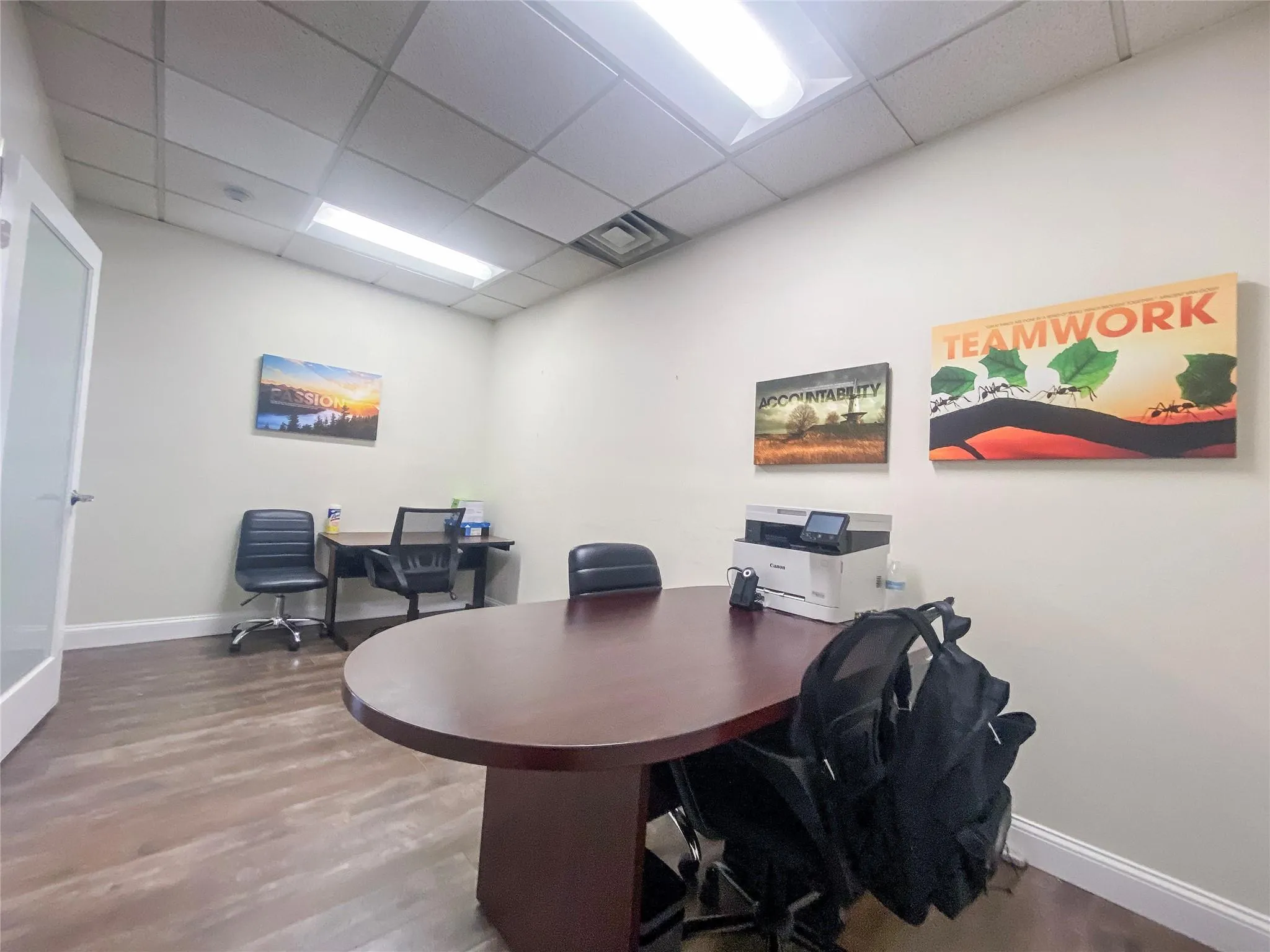 Office area with hardwood / wood-style floors and a drop ceiling Office area with hardwood / wood-style floors and a drop ceiling