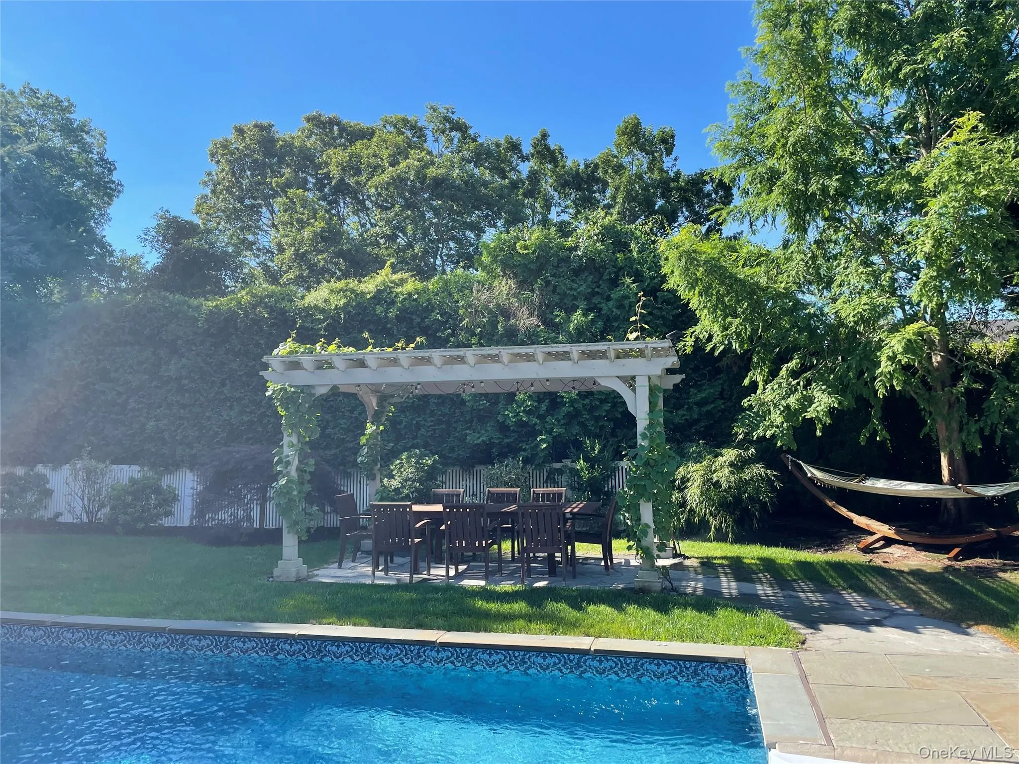 View of pool with a pergola and a lawn View of pool with a pergola and a lawn