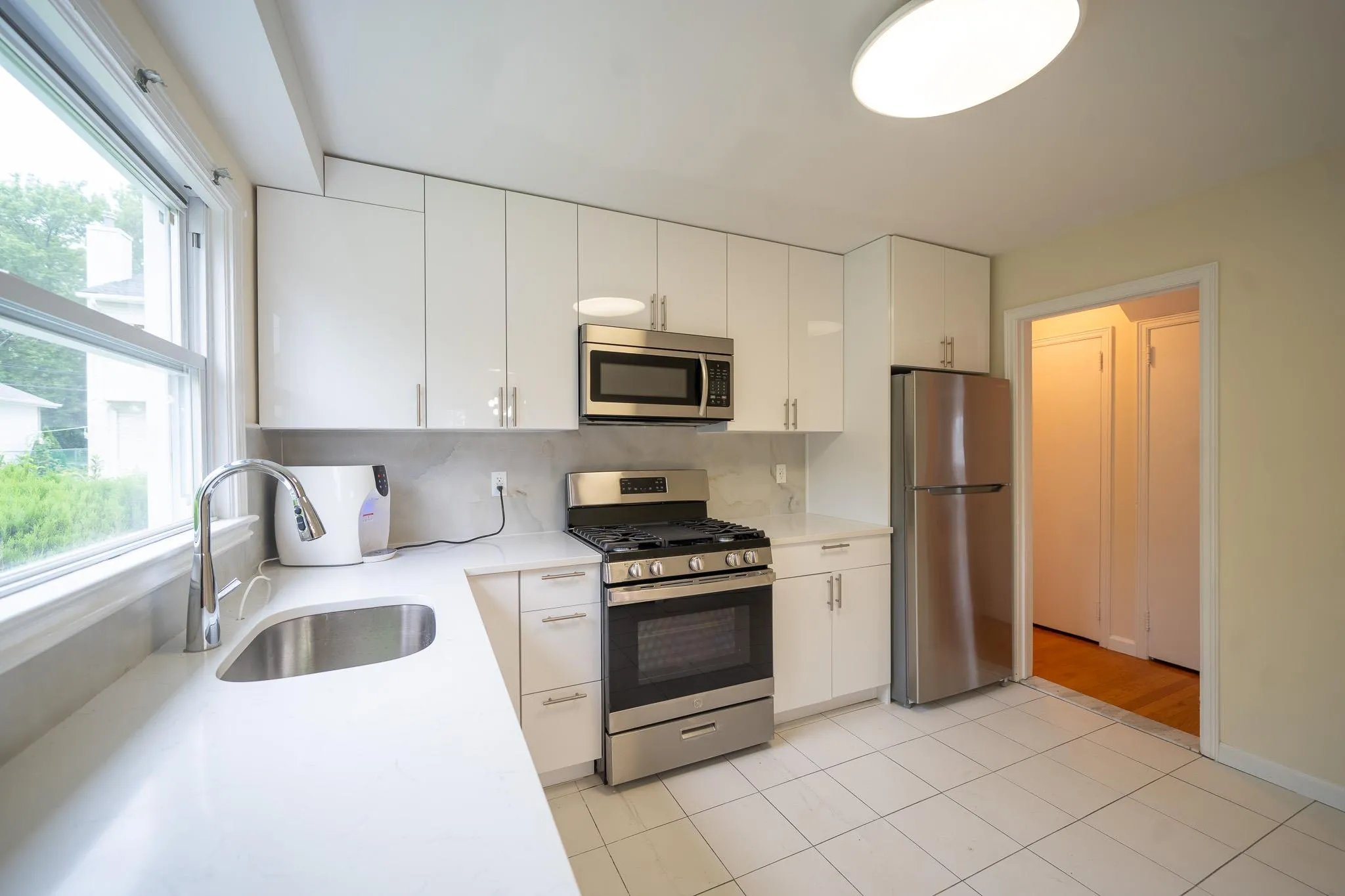 Kitchen with stainless steel appliances, healthy amount of natural light, light countertops, and white cabinets Kitchen with stainless steel appliances, healthy amount of natural light, light countertops, and white cabinets