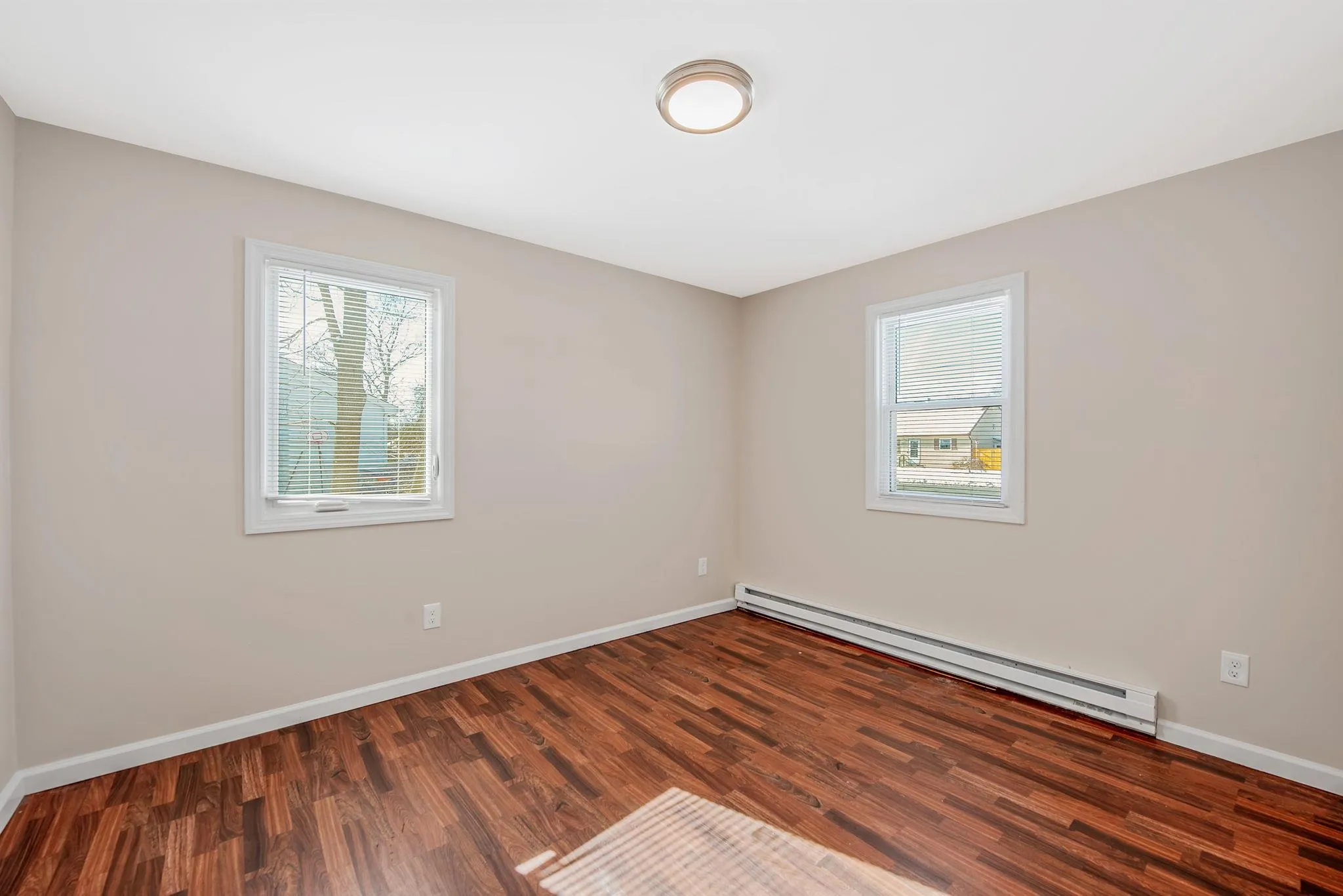 Spare room with dark hardwood / wood-style floors and baseboard heating Spare room with dark hardwood / wood-style floors and baseboard heating