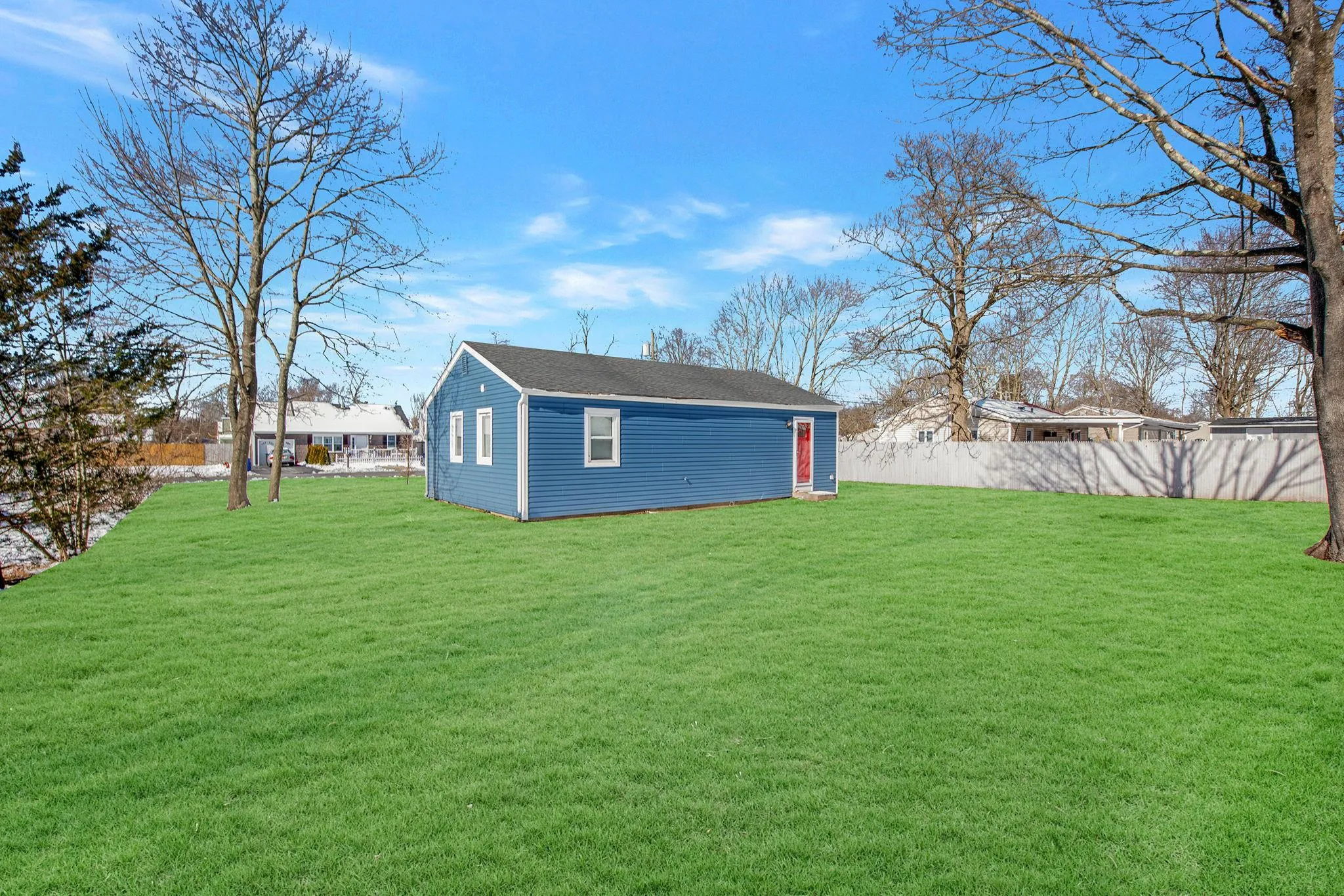 Rear view of house featuring a lawn and an outbuilding Rear view of house featuring a lawn and an outbuilding