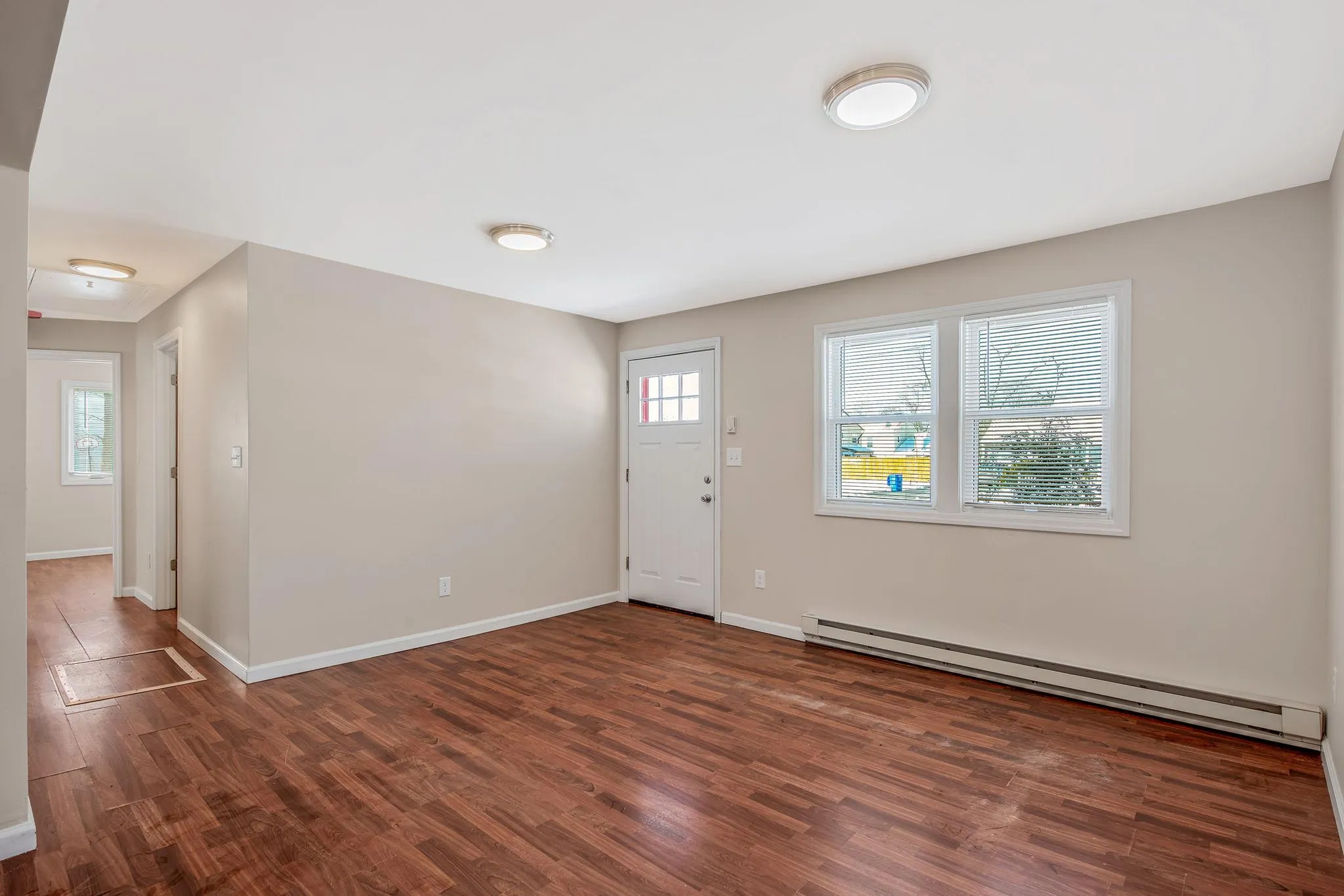 Entrance foyer with dark hardwood / wood-style floors and a baseboard heating unit Entrance foyer with dark hardwood / wood-style floors and a baseboard heating unit