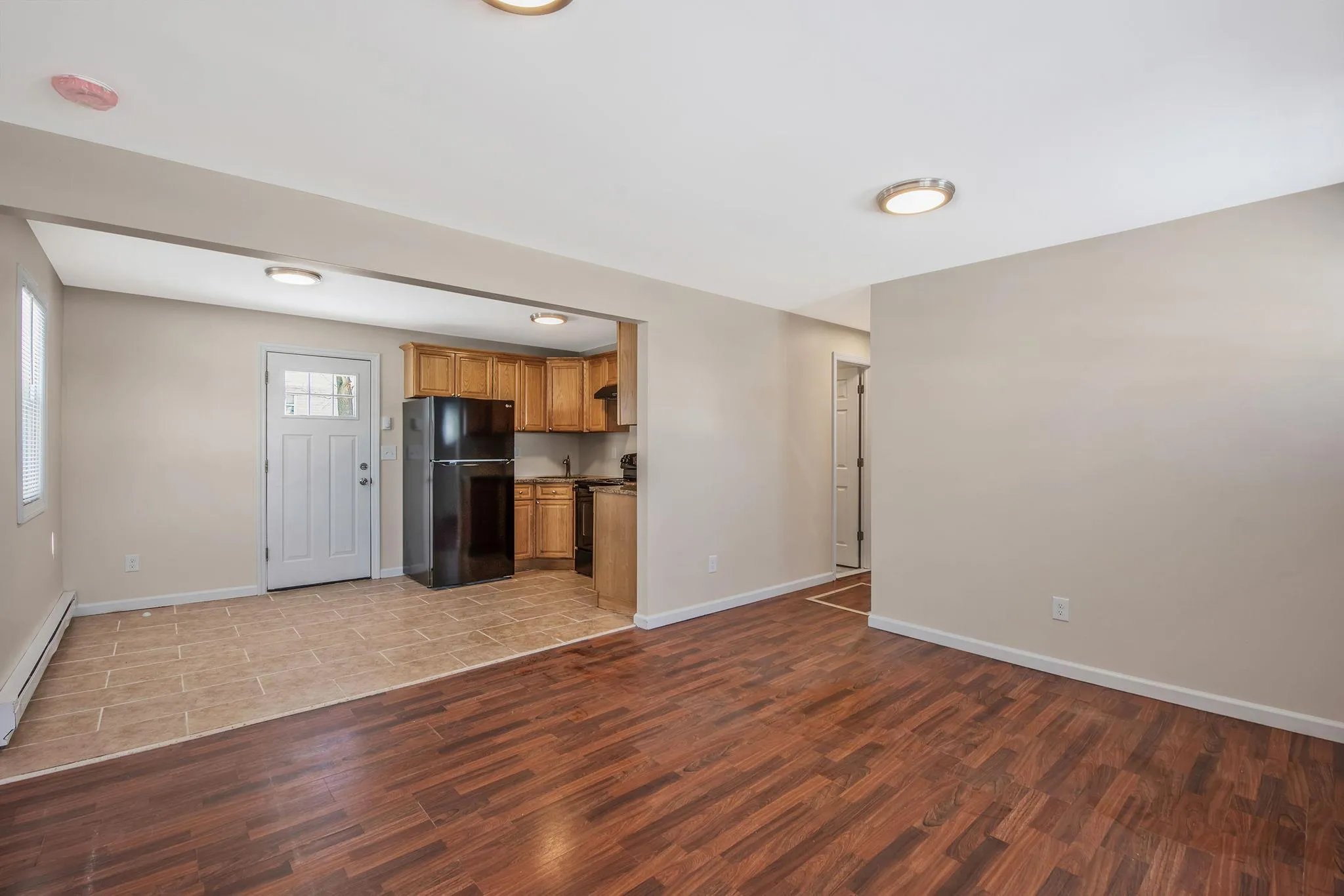 Kitchen with baseboard heating, black appliances, and light hardwood / wood-style floors Kitchen with baseboard heating, black appliances, and light hardwood / wood-style floors