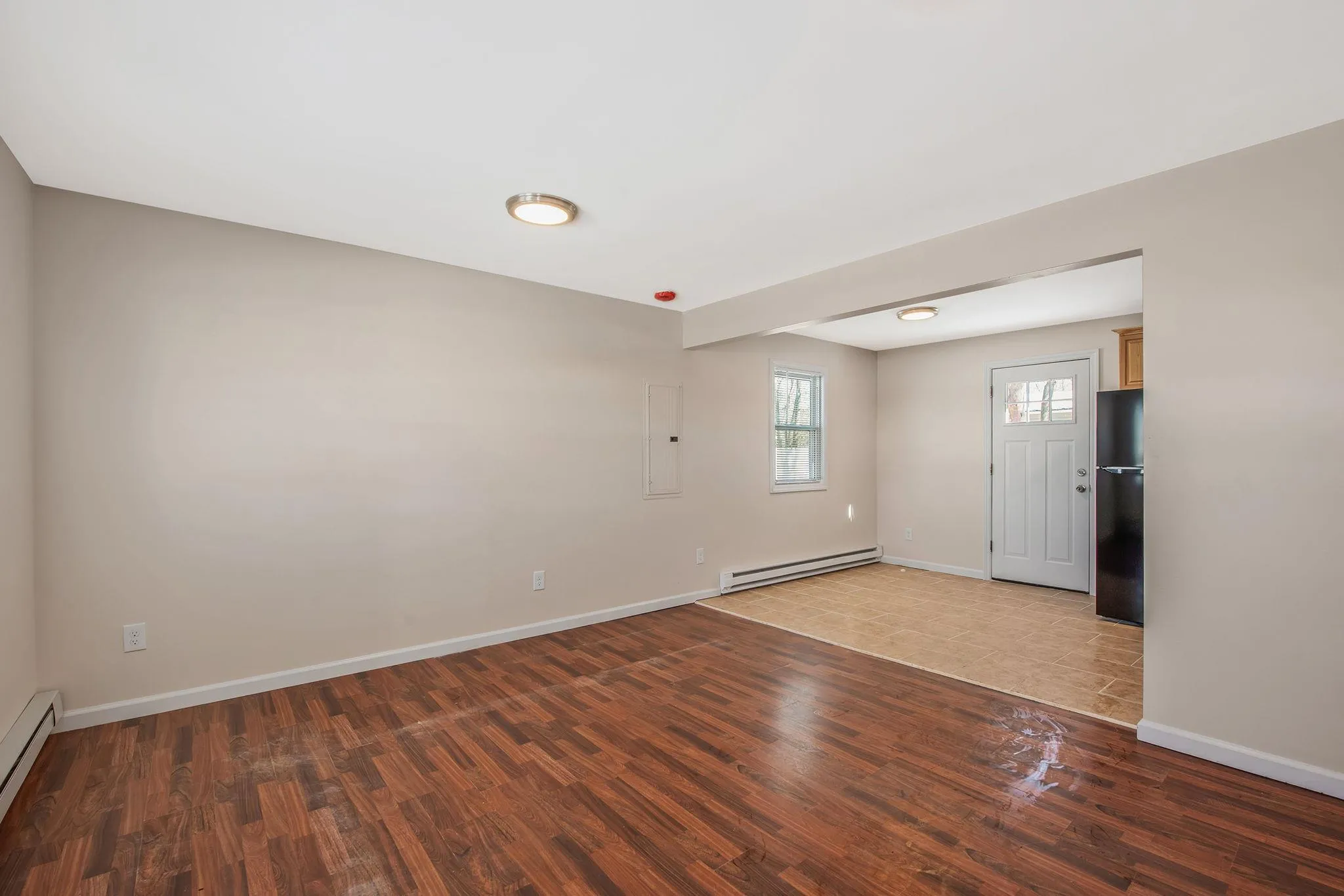 Unfurnished room with dark hardwood / wood-style flooring, a baseboard radiator, and electric panel Unfurnished room with dark hardwood / wood-style flooring, a baseboard radiator, and electric panel