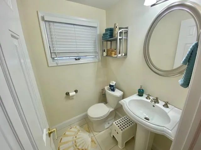 Bathroom with tile patterned flooring, toilet, and sink Bathroom with tile patterned flooring, toilet, and sink