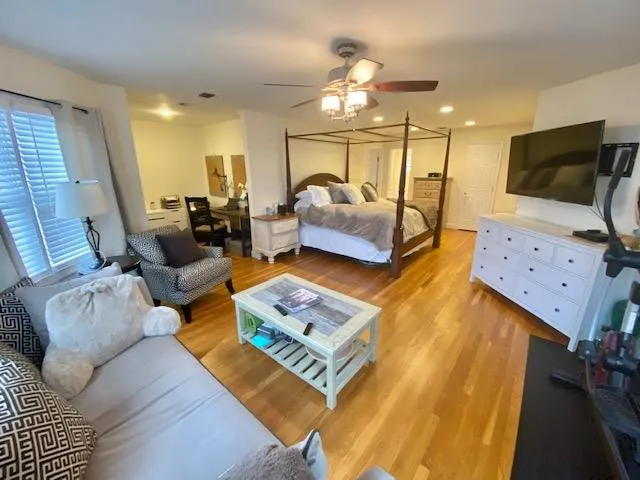 Bedroom featuring light hardwood / wood-style floors and ceiling fan Bedroom featuring light hardwood / wood-style floors and ceiling fan