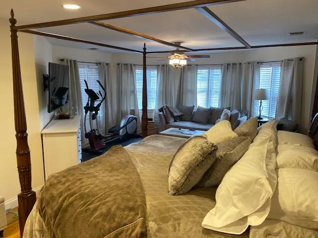 Bedroom featuring ceiling fan and wood-type flooring Bedroom featuring ceiling fan and wood-type flooring