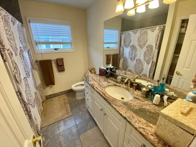 Bathroom featuring tile patterned flooring, vanity, and toilet Bathroom featuring tile patterned flooring, vanity, and toilet