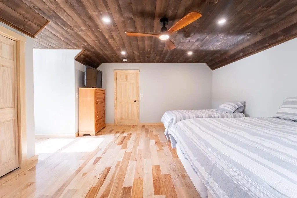 Unfurnished bedroom with wooden ceiling, vaulted ceiling, and light hardwood / wood-style floors Unfurnished bedroom with wooden ceiling, vaulted ceiling, and light hardwood / wood-style floors