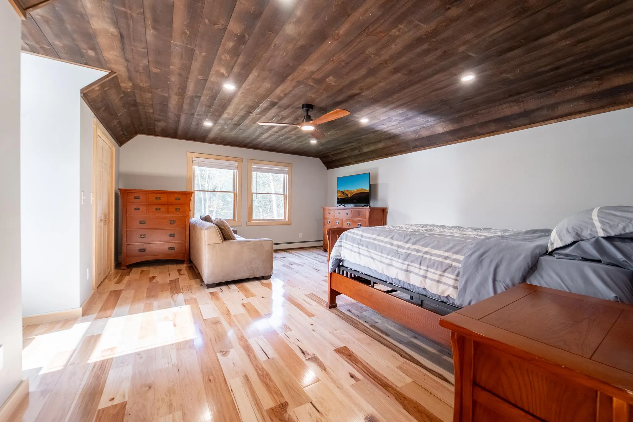Bedroom with light wood-type flooring, ceiling fan, a baseboard heating unit, wooden ceiling, and lofted ceiling Bedroom with light wood-type flooring, ceiling fan, a baseboard heating unit, wooden ceiling, and lofted ceiling