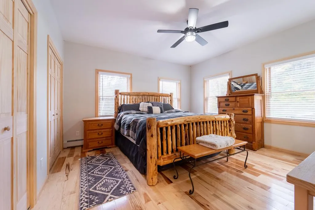 Bedroom featuring light hardwood / wood-style floors, baseboard heating, and ceiling fan Bedroom featuring light hardwood / wood-style floors, baseboard heating, and ceiling fan