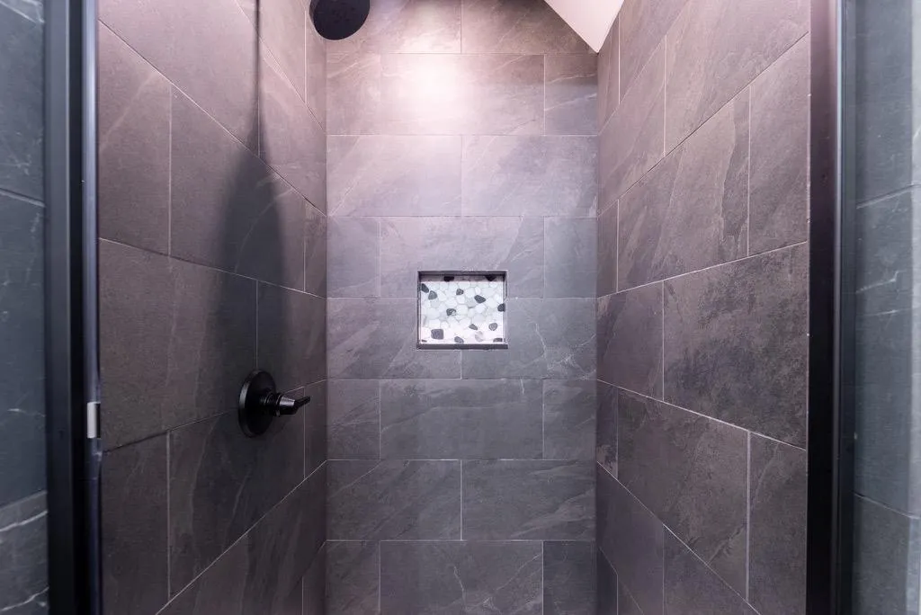 Bathroom with a tile shower and lofted ceiling Bathroom with a tile shower and lofted ceiling