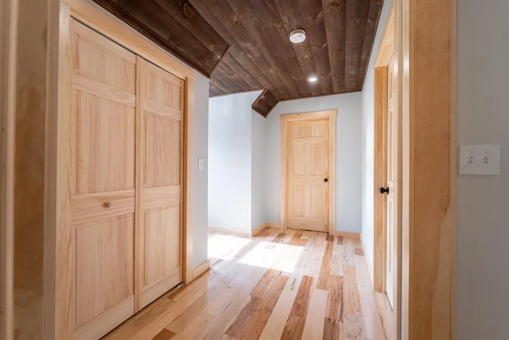 Corridor with light hardwood / wood-style floors and wooden ceiling Corridor with light hardwood / wood-style floors and wooden ceiling
