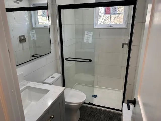 Bathroom with vanity, an enclosed shower, and toilet Bathroom with vanity, an enclosed shower, and toilet