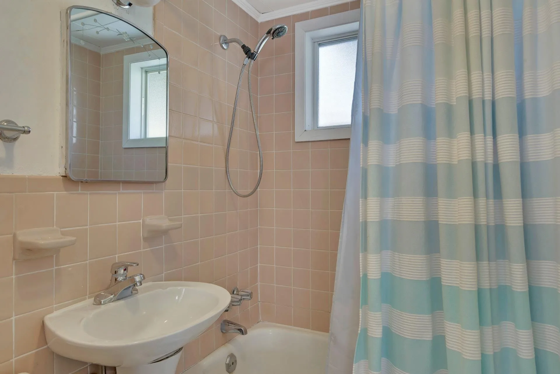 Bathroom with sink, backsplash, shower / tub combo with curtain, tile walls, and ornamental molding Bathroom with sink, backsplash, shower / tub combo with curtain, tile walls, and ornamental molding