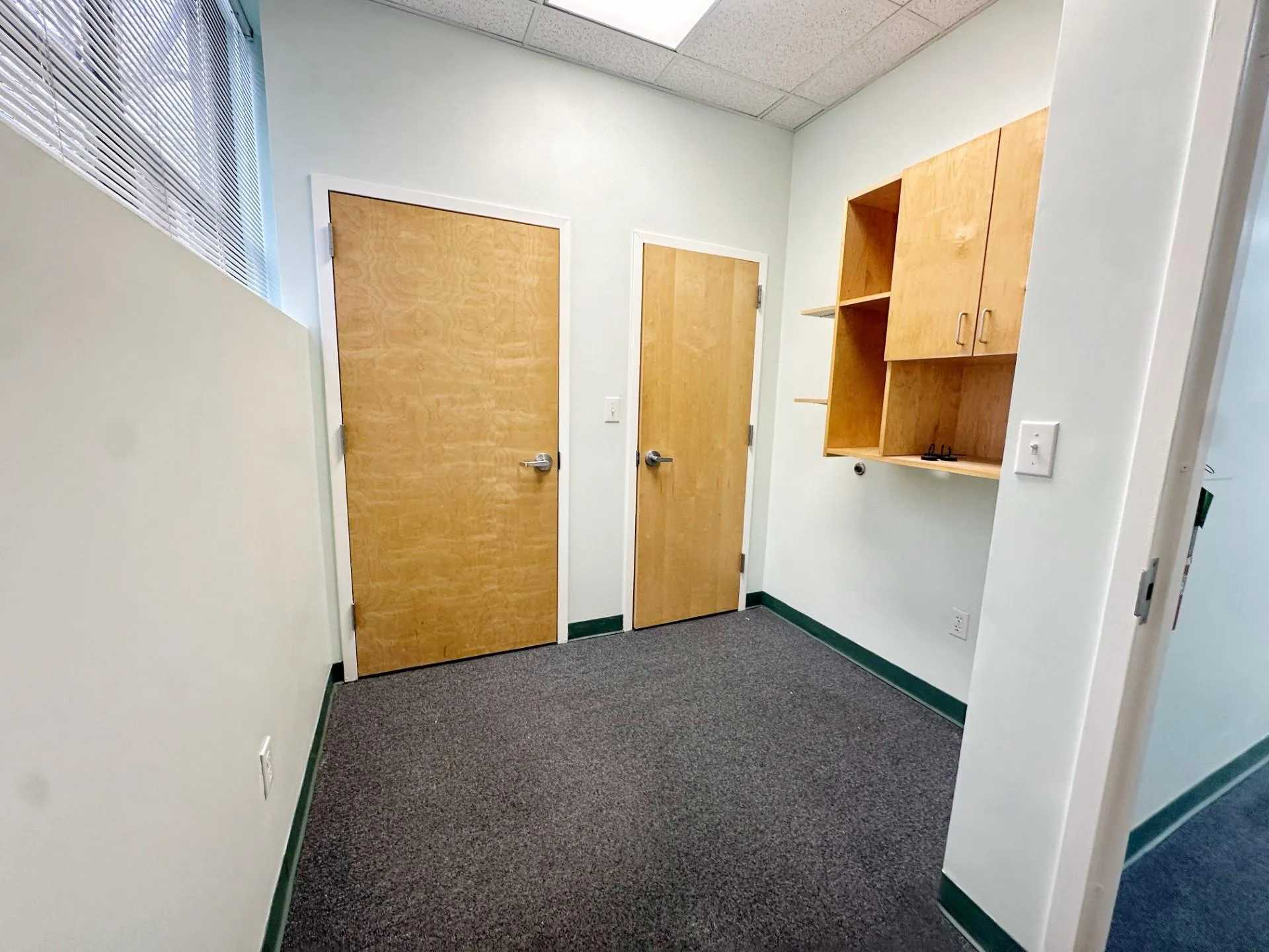 Corridor with a paneled ceiling and dark carpet Corridor with a paneled ceiling and dark carpet