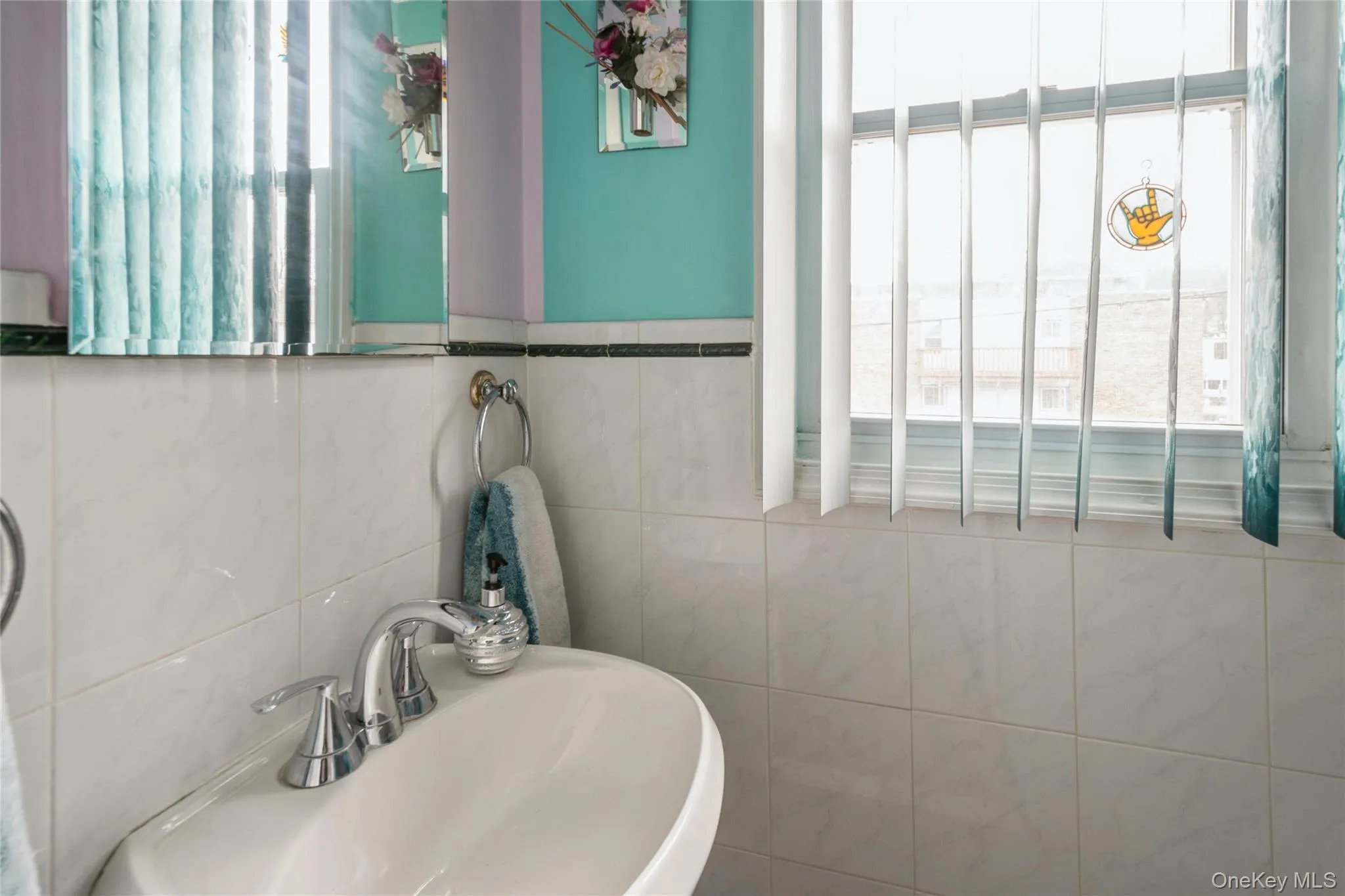 Bathroom with a wealth of natural light, tile walls, and sink Bathroom with a wealth of natural light, tile walls, and sink