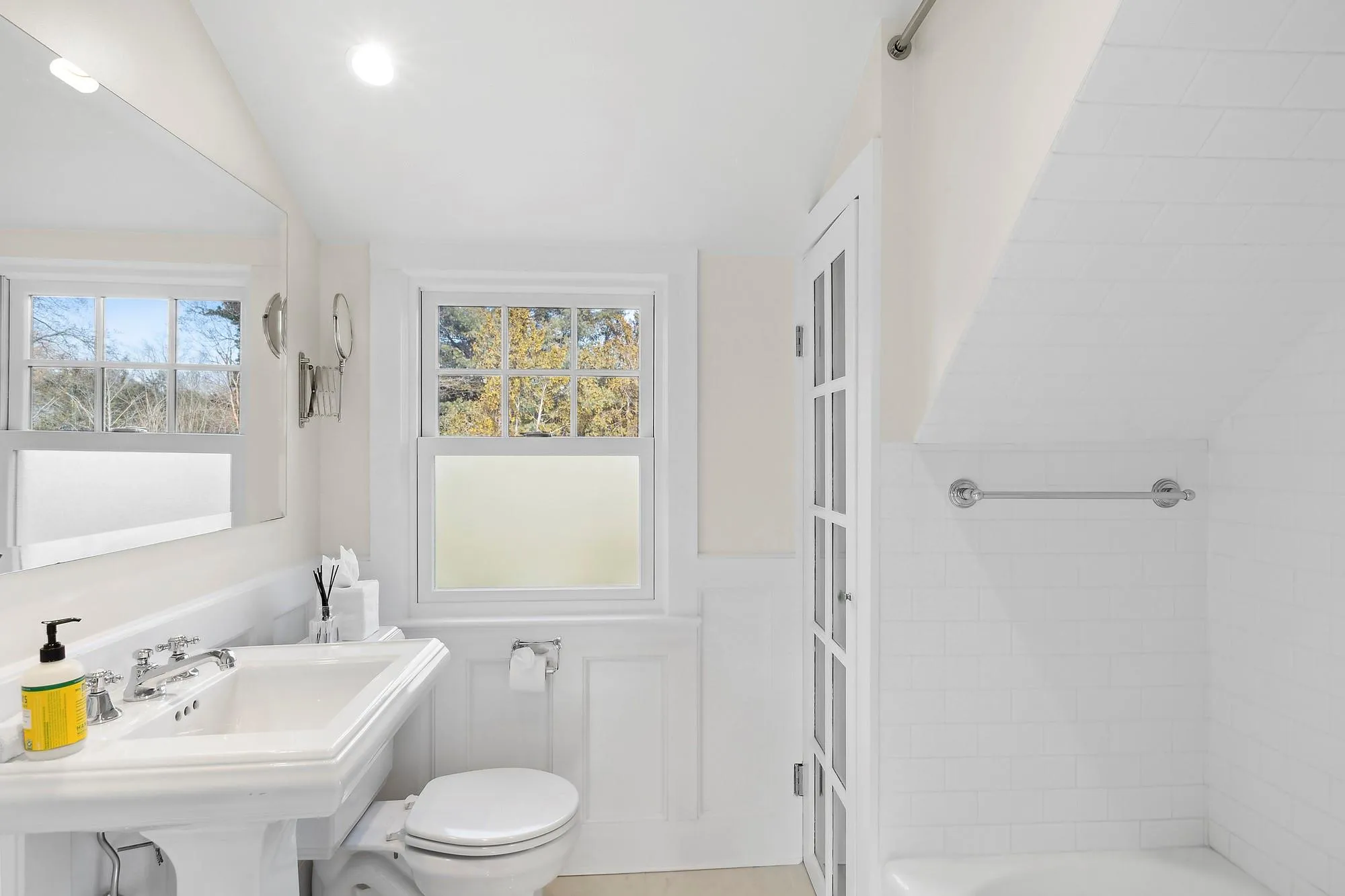 Bathroom featuring toilet, a tub to relax in, vaulted ceiling, and sink Bathroom featuring toilet, a tub to relax in, vaulted ceiling, and sink