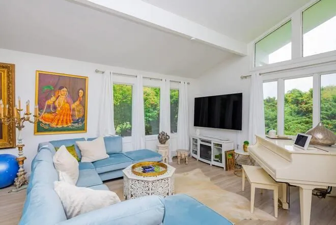 Living room featuring vaulted ceiling with beams and light wood-type flooring Living room featuring vaulted ceiling with beams and light wood-type flooring