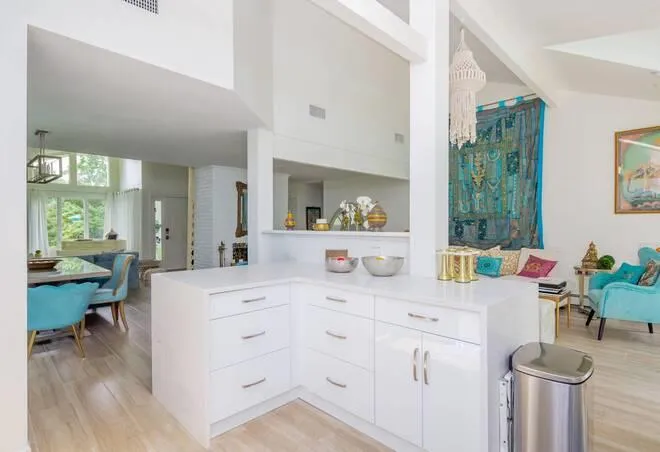 Kitchen with kitchen peninsula, white cabinetry, and light hardwood / wood-style flooring Kitchen with kitchen peninsula, white cabinetry, and light hardwood / wood-style flooring