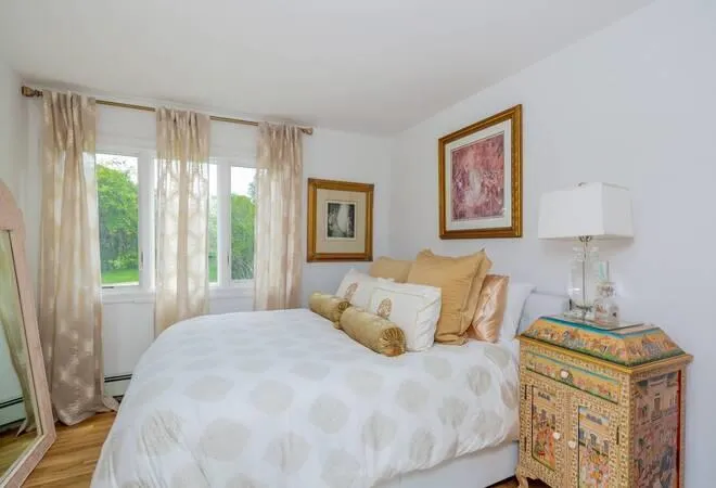 Bedroom with baseboard heating and light hardwood flooring Bedroom with baseboard heating and light hardwood flooring