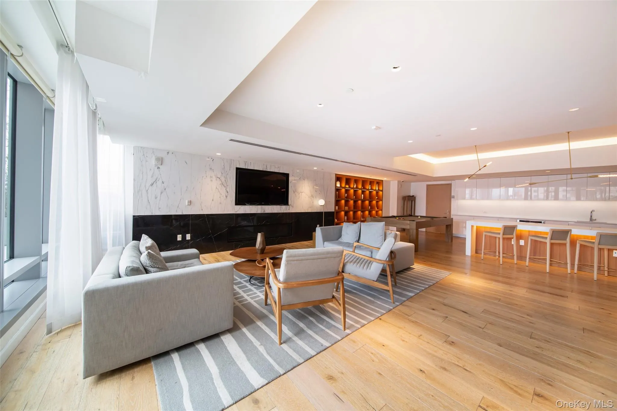 Living room with a tray ceiling and light hardwood / wood-style flooring Living room with a tray ceiling and light hardwood / wood-style flooring