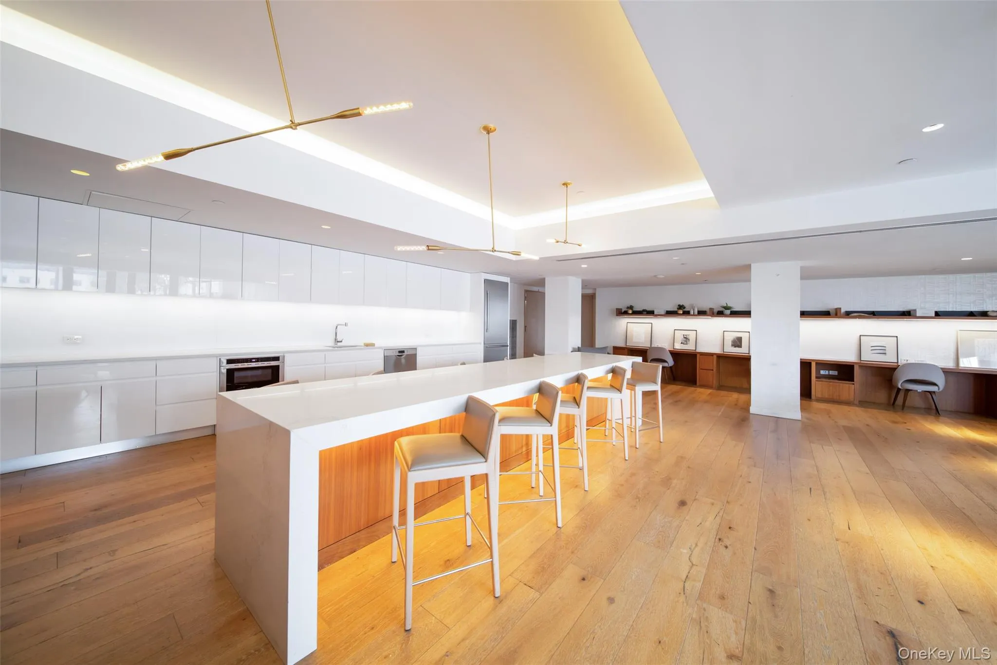 Kitchen with hanging light fixtures, a spacious island, a breakfast bar area, white cabinets, and appliances with stainless steel finishes Kitchen with hanging light fixtures, a spacious island, a breakfast bar area, white cabinets, and appliances with stainless steel finishes