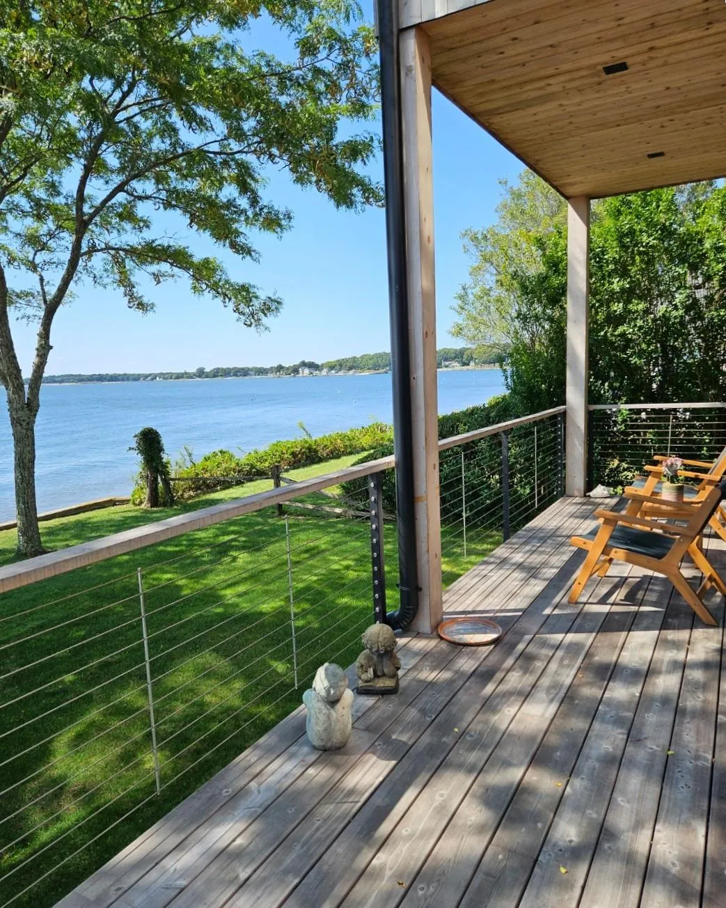Wooden deck with a yard and a water view Wooden deck with a yard and a water view