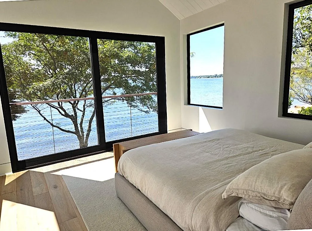 Bedroom featuring a water view and lofted ceiling Bedroom featuring a water view and lofted ceiling