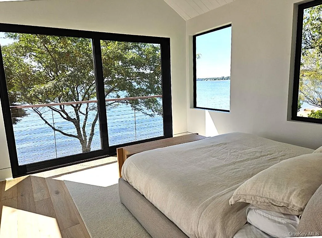 Bedroom featuring a water view and lofted ceiling Bedroom featuring a water view and lofted ceiling