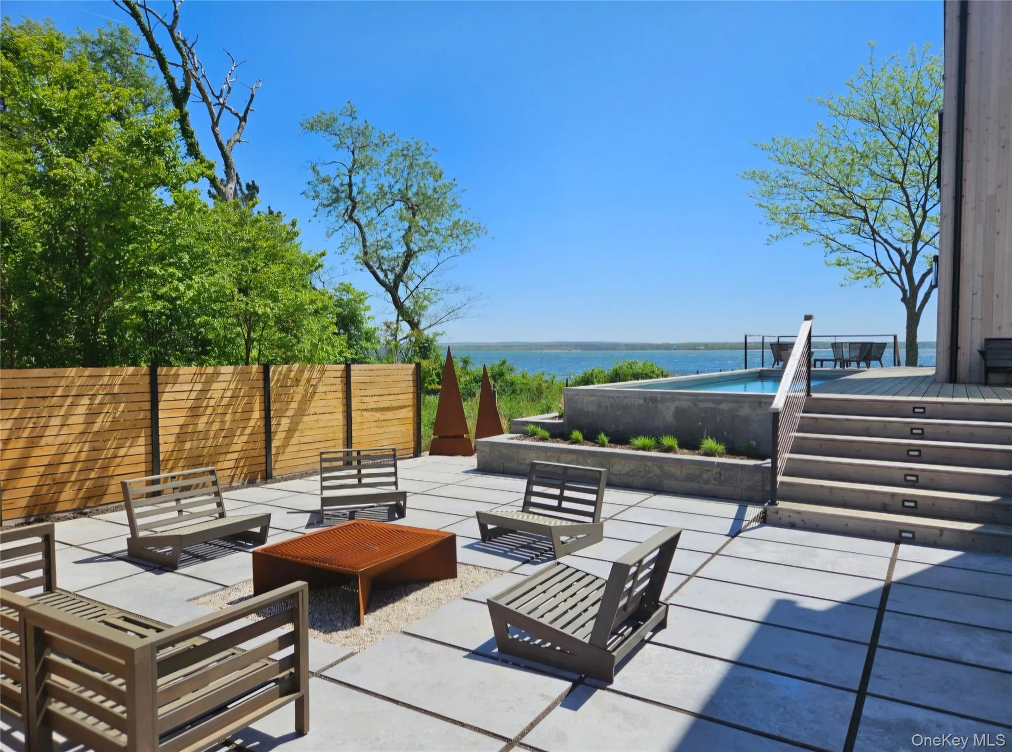 View of patio featuring a water view, an outdoor living space, and fence View of patio featuring a water view, an outdoor living space, and fence