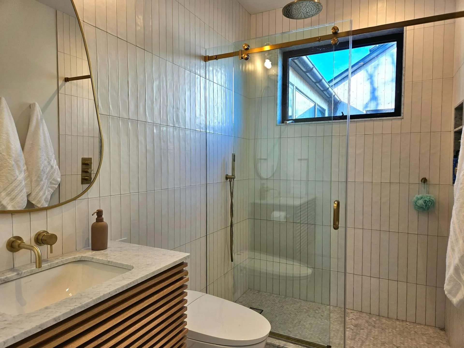 Bathroom featuring vanity, backsplash, toilet, a shower stall, and tile walls Bathroom featuring vanity, backsplash, toilet, a shower stall, and tile walls