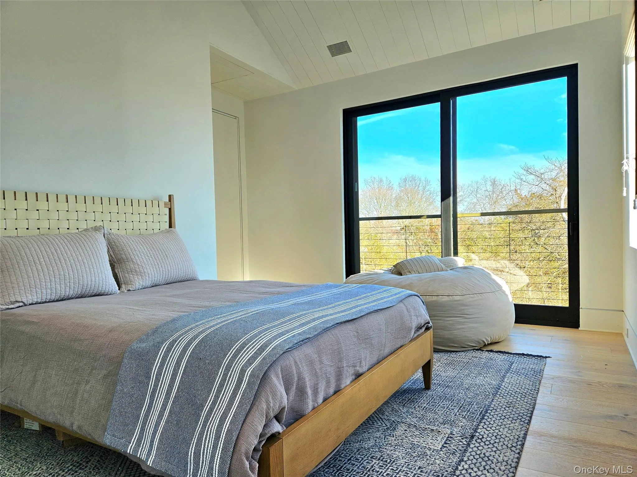 Bedroom with wood-type flooring, vaulted ceiling, and visible vents Bedroom with wood-type flooring, vaulted ceiling, and visible vents