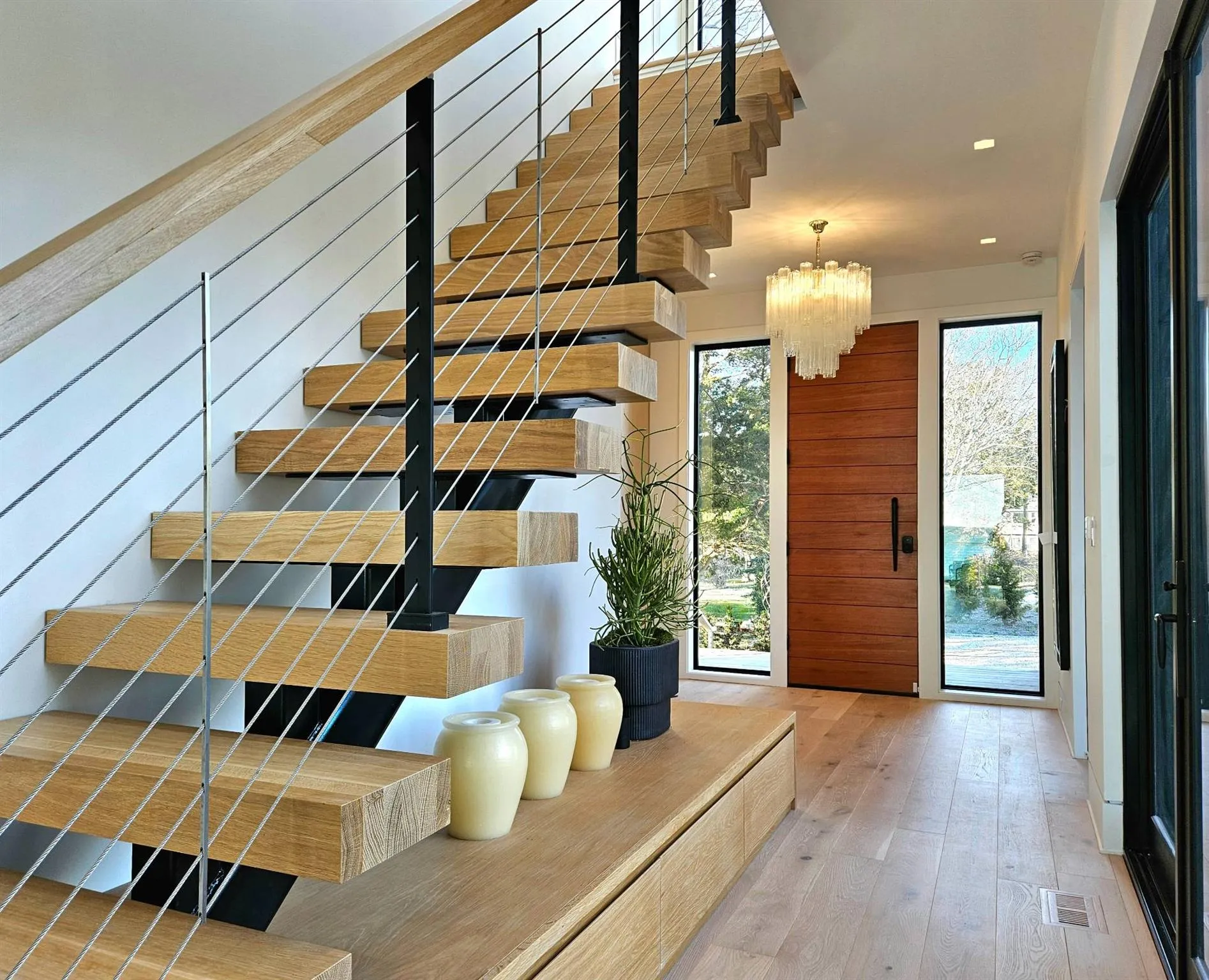 Stairs featuring wood walls, wood finished floors, visible vents, and a notable chandelier Stairs featuring wood walls, wood finished floors, visible vents, and a notable chandelier