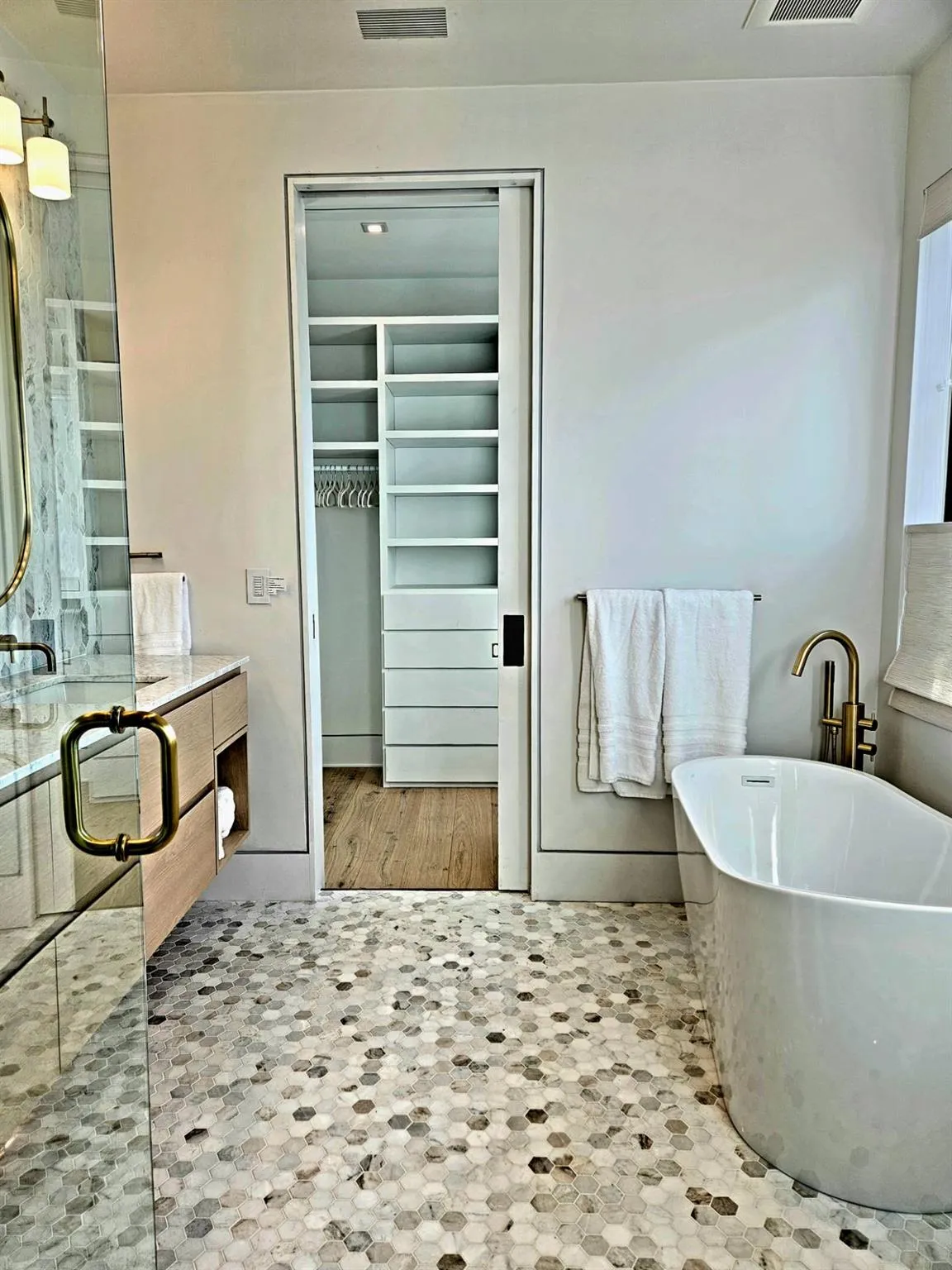 Bathroom featuring a freestanding bath, a spacious closet, visible vents, and a stall shower Bathroom featuring a freestanding bath, a spacious closet, visible vents, and a stall shower