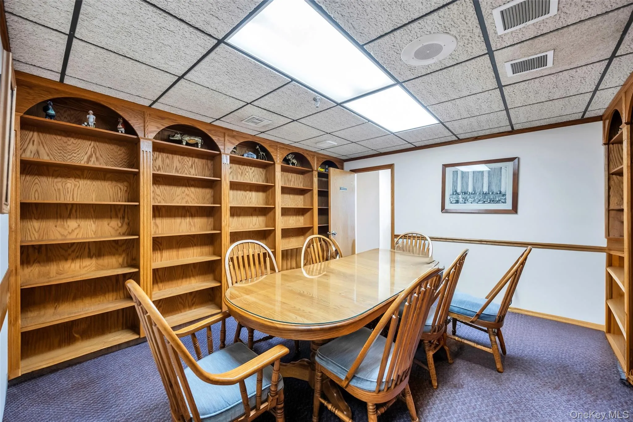 Unfurnished dining area with built in shelves, a paneled ceiling, and carpet Unfurnished dining area with built in shelves, a paneled ceiling, and carpet
