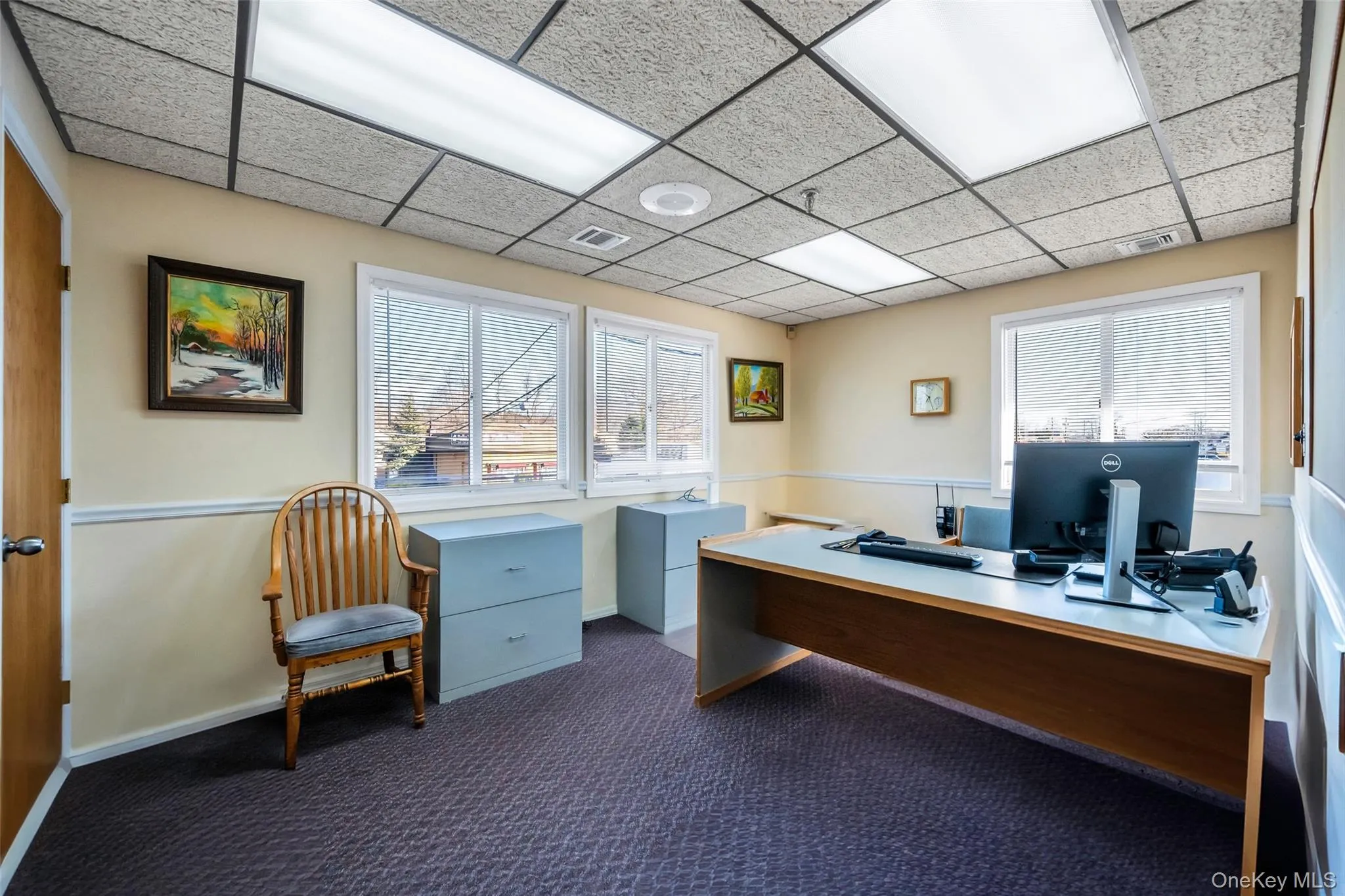 Carpeted office with a drop ceiling Carpeted office with a drop ceiling