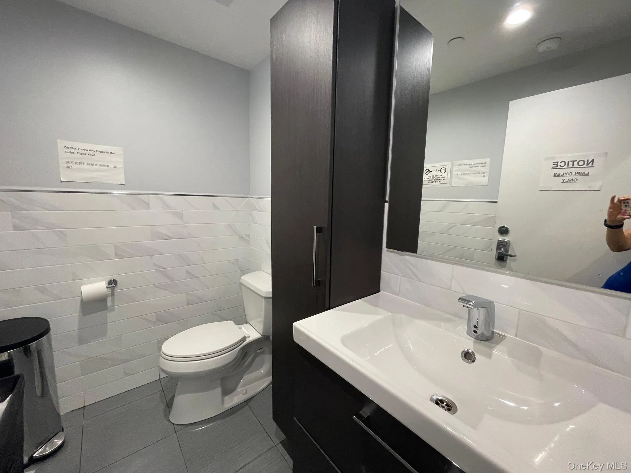 Bathroom featuring toilet, tile patterned flooring, tile walls, and vanity Bathroom featuring toilet, tile patterned flooring, tile walls, and vanity