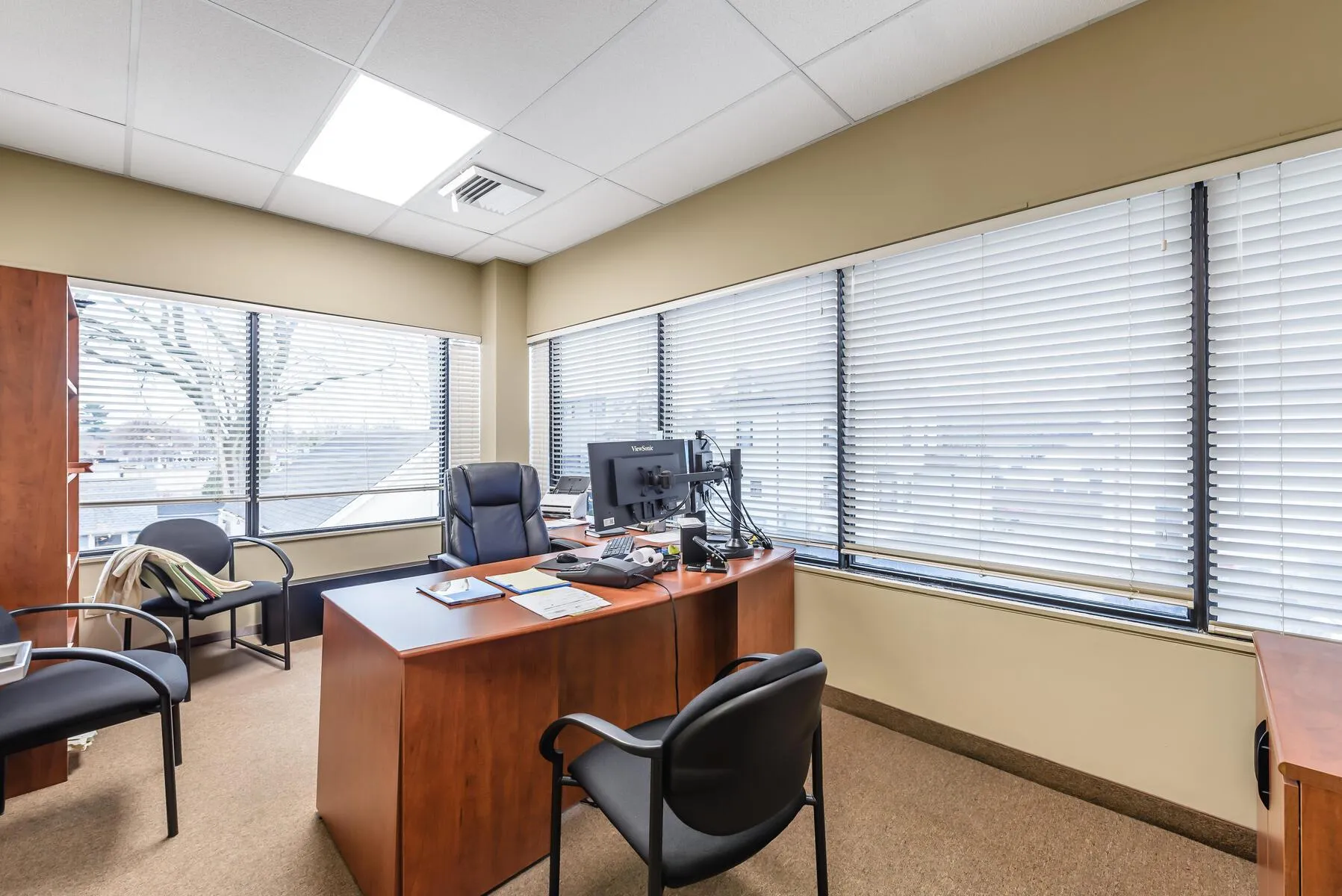 Office space featuring light colored carpet and a drop ceiling Office space featuring light colored carpet and a drop ceiling