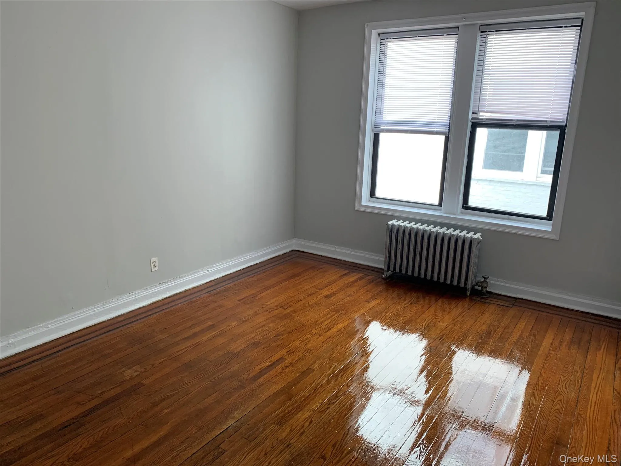 Spare room with radiator heating unit and hardwood / wood-style floors Spare room with radiator heating unit and hardwood / wood-style floors