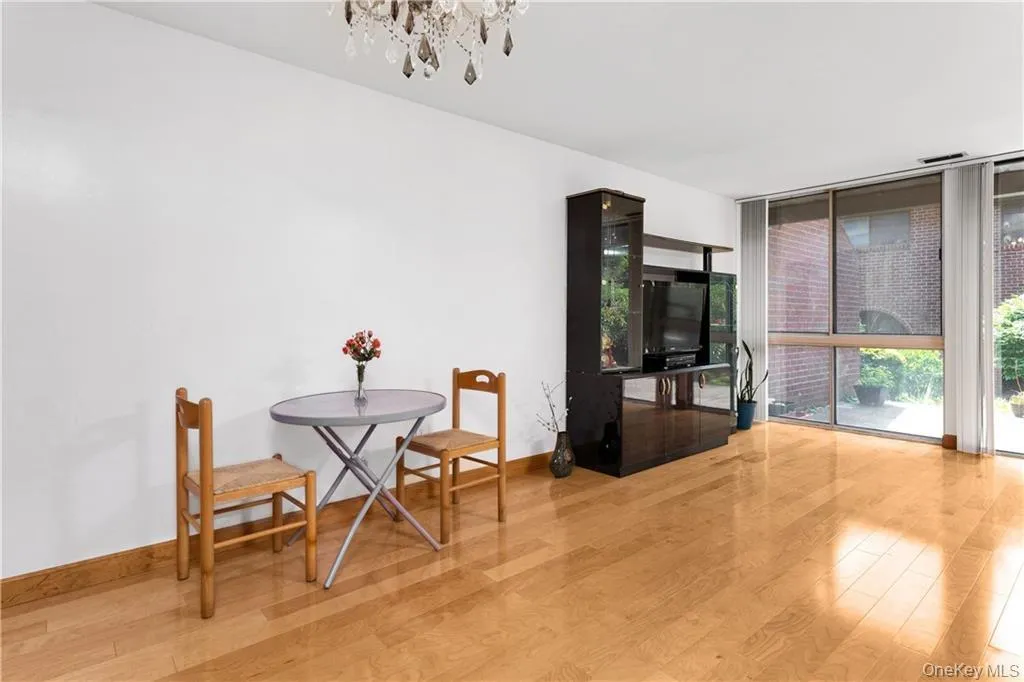 Dining space with expansive windows, an inviting chandelier, and light wood-type flooring Dining space with expansive windows, an inviting chandelier, and light wood-type flooring