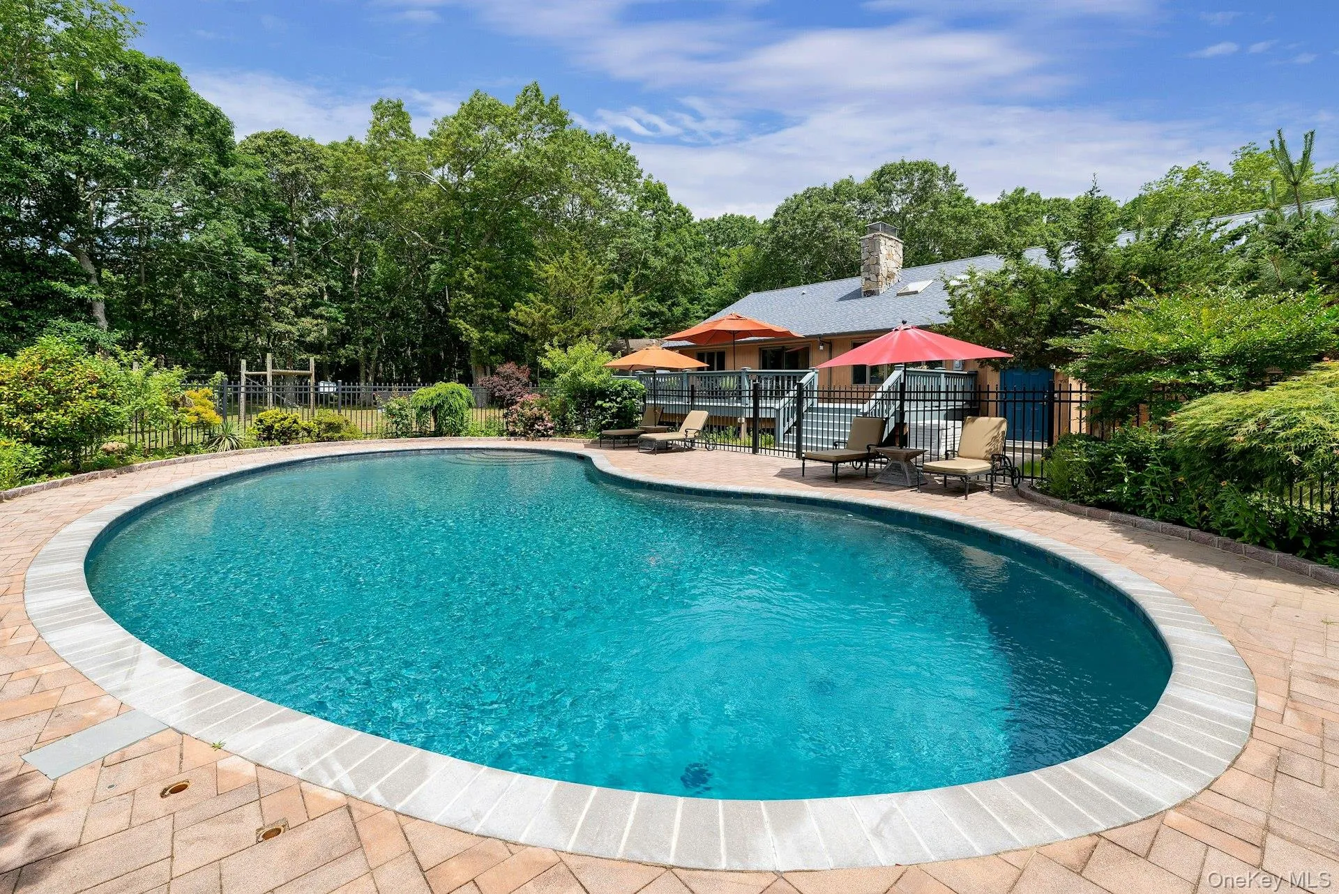 View of pool featuring a patio area and view of scattered trees View of pool featuring a patio area and view of scattered trees