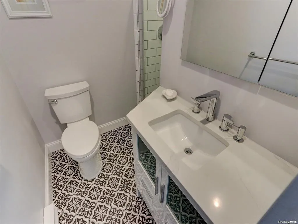 Bathroom featuring toilet, tile patterned flooring, and sink Bathroom featuring toilet, tile patterned flooring, and sink