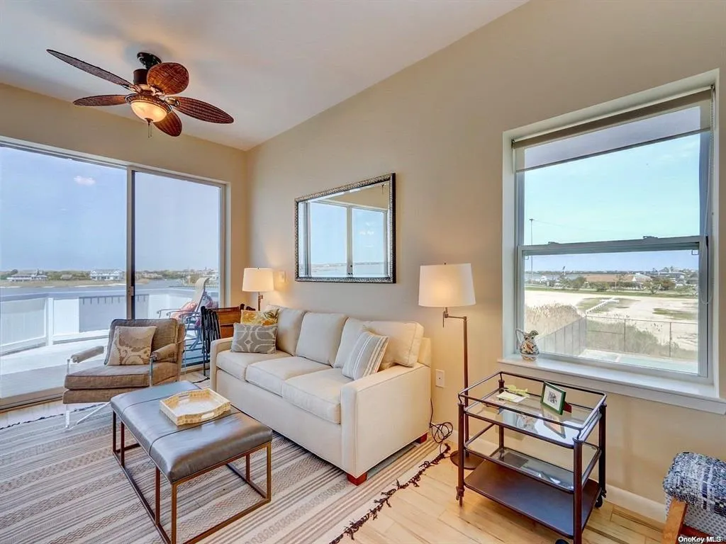 Living room featuring ceiling fan, a water view, and light hardwood / wood-style flooring Living room featuring ceiling fan, a water view, and light hardwood / wood-style flooring