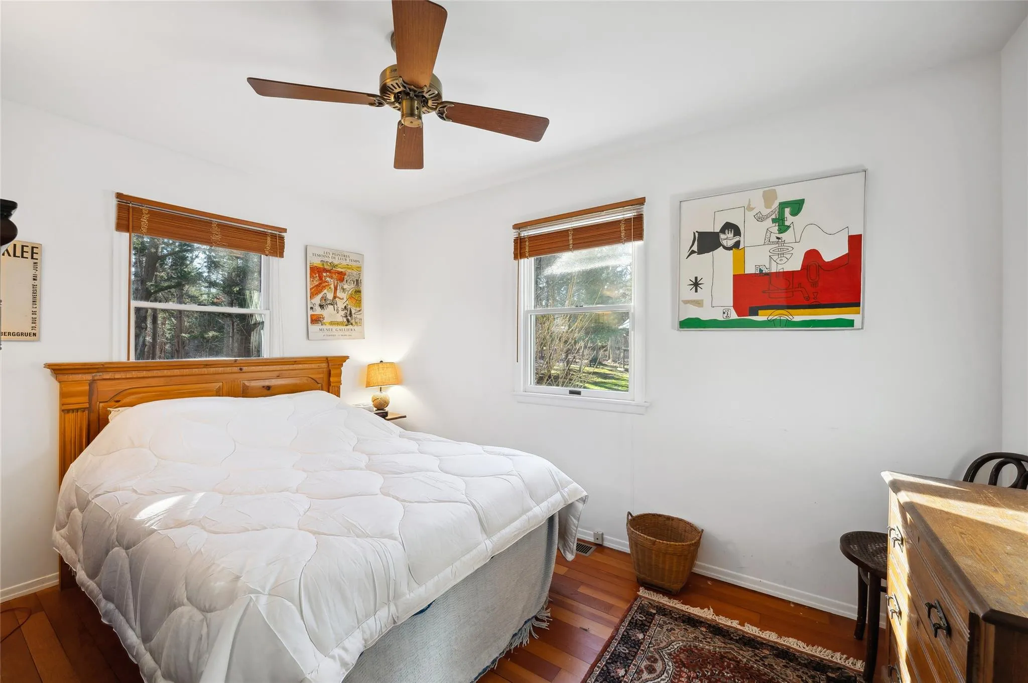 Bedroom with ceiling fan, hardwood / wood-style flooring, and multiple windows Bedroom with ceiling fan, hardwood / wood-style flooring, and multiple windows