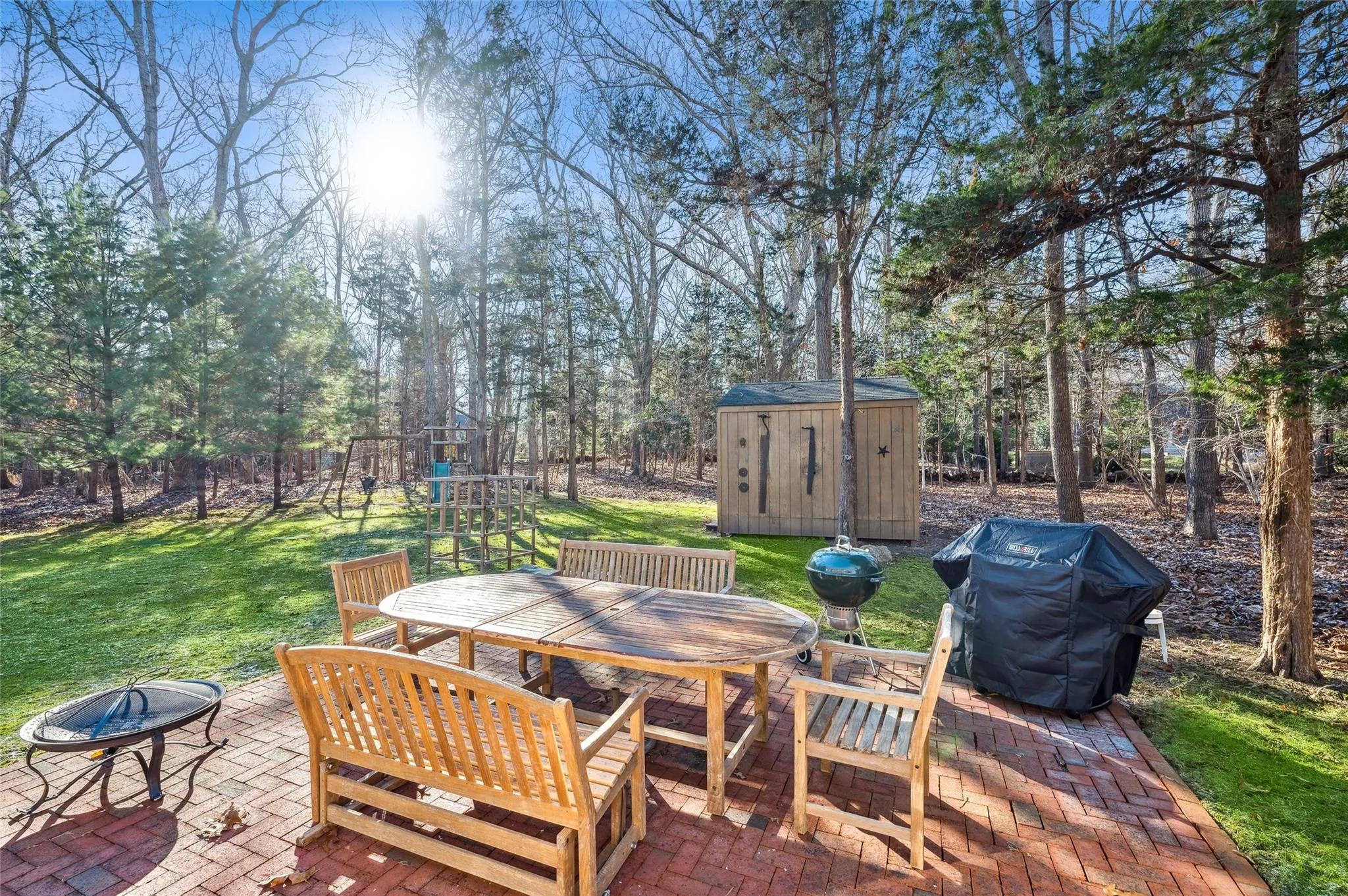 View of patio featuring a playground, a grill, a shed, and an outdoor fire pit View of patio featuring a playground, a grill, a shed, and an outdoor fire pit