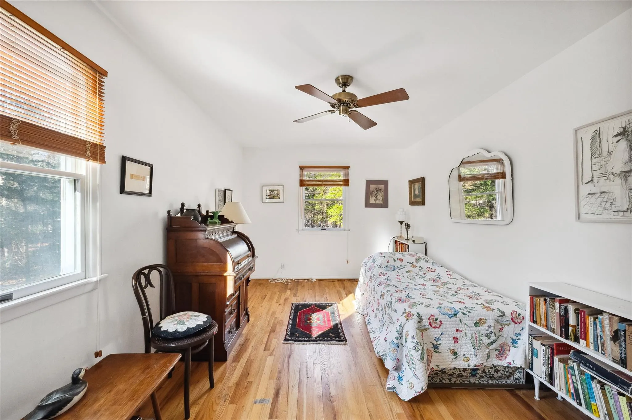 Bedroom featuring light wood-type flooring, ceiling fan, and multiple windows Bedroom featuring light wood-type flooring, ceiling fan, and multiple windows