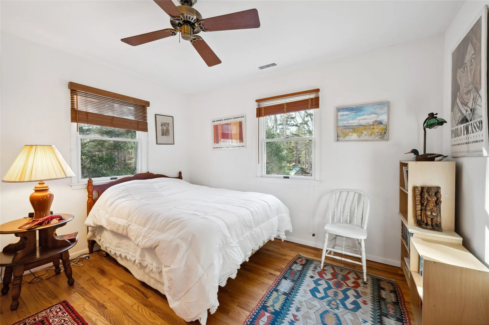 Bedroom with ceiling fan, wood-type flooring, and multiple windows Bedroom with ceiling fan, wood-type flooring, and multiple windows